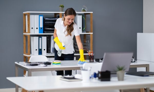 stock-photo-young-worker-cleaning-desk-with-rag-in-office-1619486272-transformed